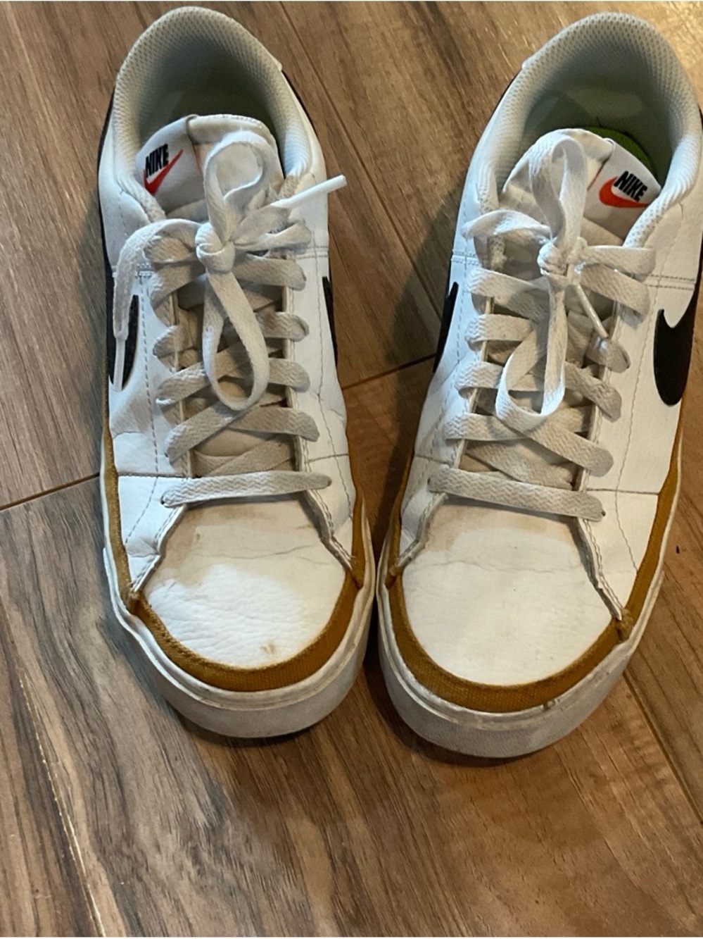 Nike White Low-Top Sneakers with Black Swoosh and Mustard Accent